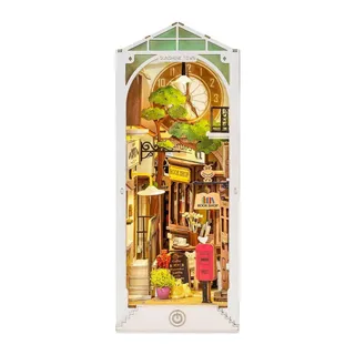 Book nook Sunshine Town monté : ruelle, horloge et arbre sous un toit vitré vert, sur fond blanc
