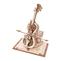 Violoncelle mécanique en bois clair dressé sur un socle en forme de livre ouvert