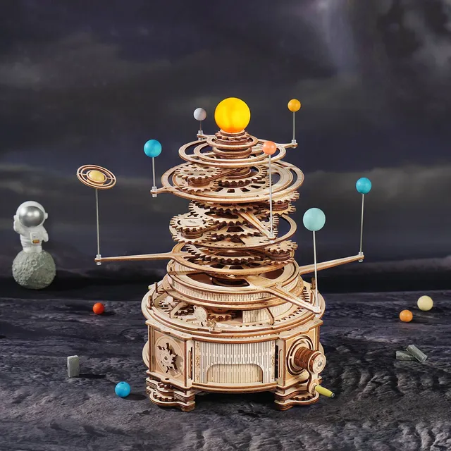 Planétaire en bois posé sur un sol lunaire gris, ciel étoilé sombre et figurine d'astronaute