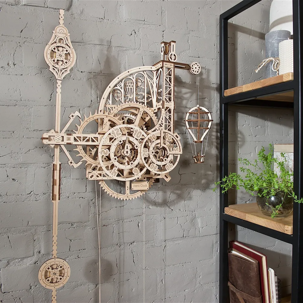 Horloge en bois accrochée à un mur de briques gris près d'une étagère et d'une plante verte