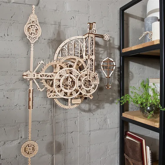 Horloge en bois accrochée à un mur de briques gris près d'une étagère et d'une plante verte