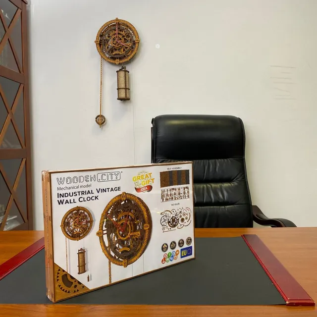 L’horloge accrochée au mur d’un bureau, au-dessus d’un fauteuil en cuir, sa boîte posée sur le bureau