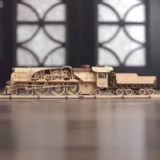 Locomotive et tender de profil sur un sol brillant devant une grande fenêtre floutée