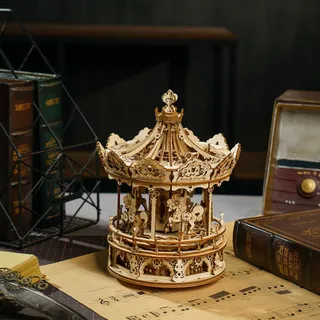 Carrousel de bois sur une partition, entre des livres reliés et un poste de radio ancien
