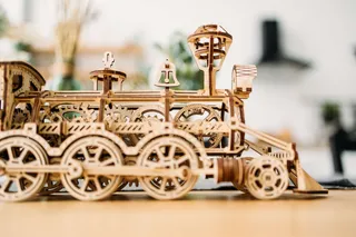 La locomotive de profil : roues motrices, bielles, chaudière, cloche et cheminée évasée