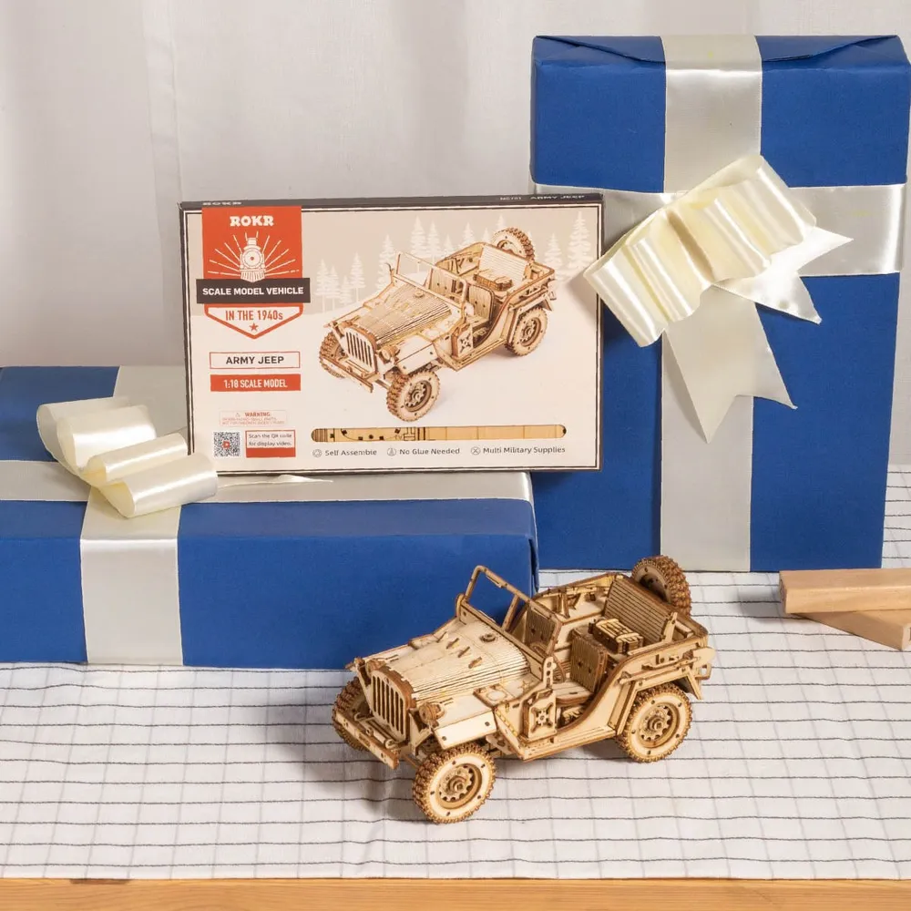 La jeep en bois devant sa boîte ROKR et des paquets cadeaux bleus à ruban blanc