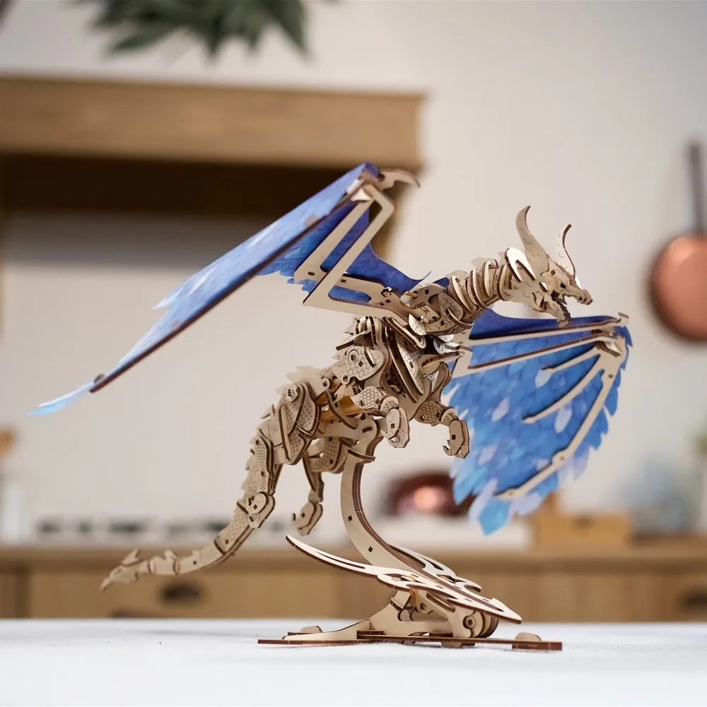 Le dragon en bois aux ailes bleues posé sur une table, dans une cuisine
