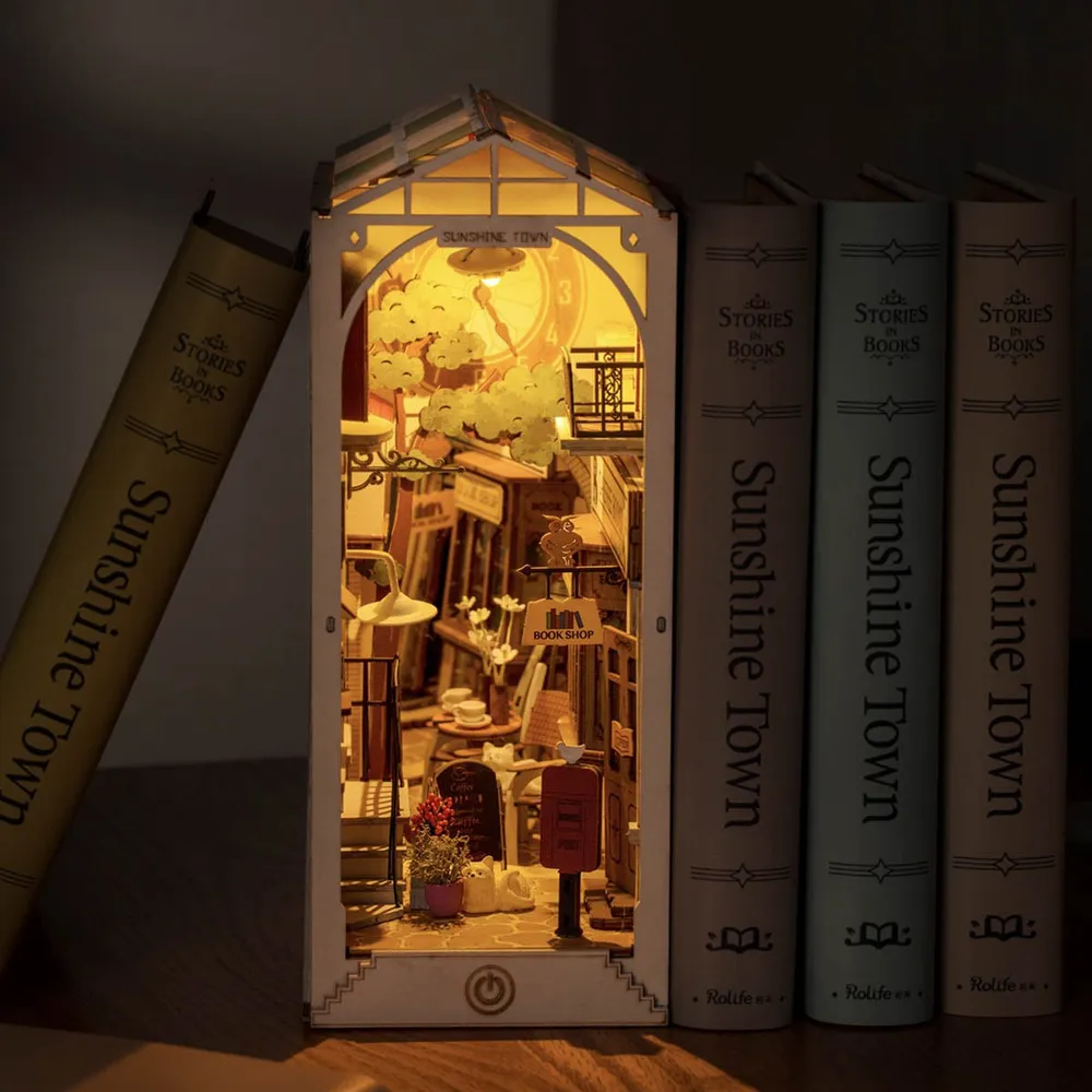 La ruelle éclairée le soir, rangée entre des livres sur une étagère