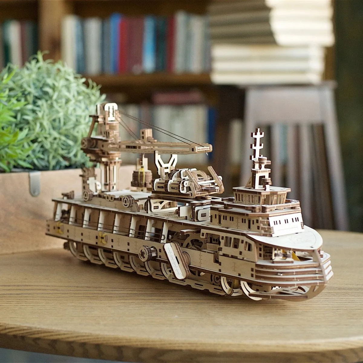 Le bateau de recherche en bois posé sur une table devant une bibliothèque