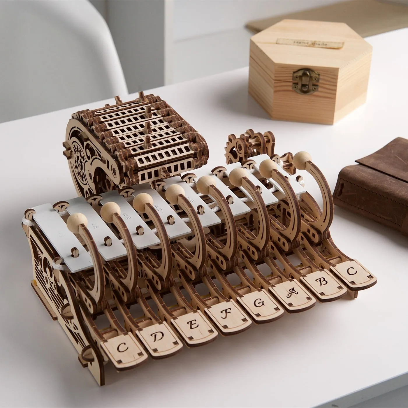 Le célesta en bois posé sur une table blanche, à côté d'une boîte à bijoux en bois