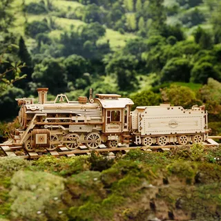 Locomotive en bois de profil sur ses rails devant des collines verdoyantes floutées