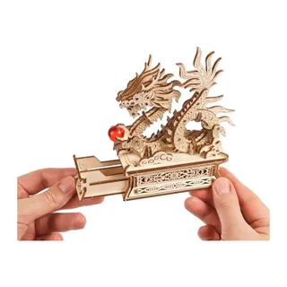 Deux mains tiennent le socle, tiroir secret sorti, sous le dragon et sa perle rouge