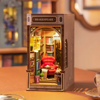 Le book nook éclairé posé sur un bureau en bois, vu de trois quarts