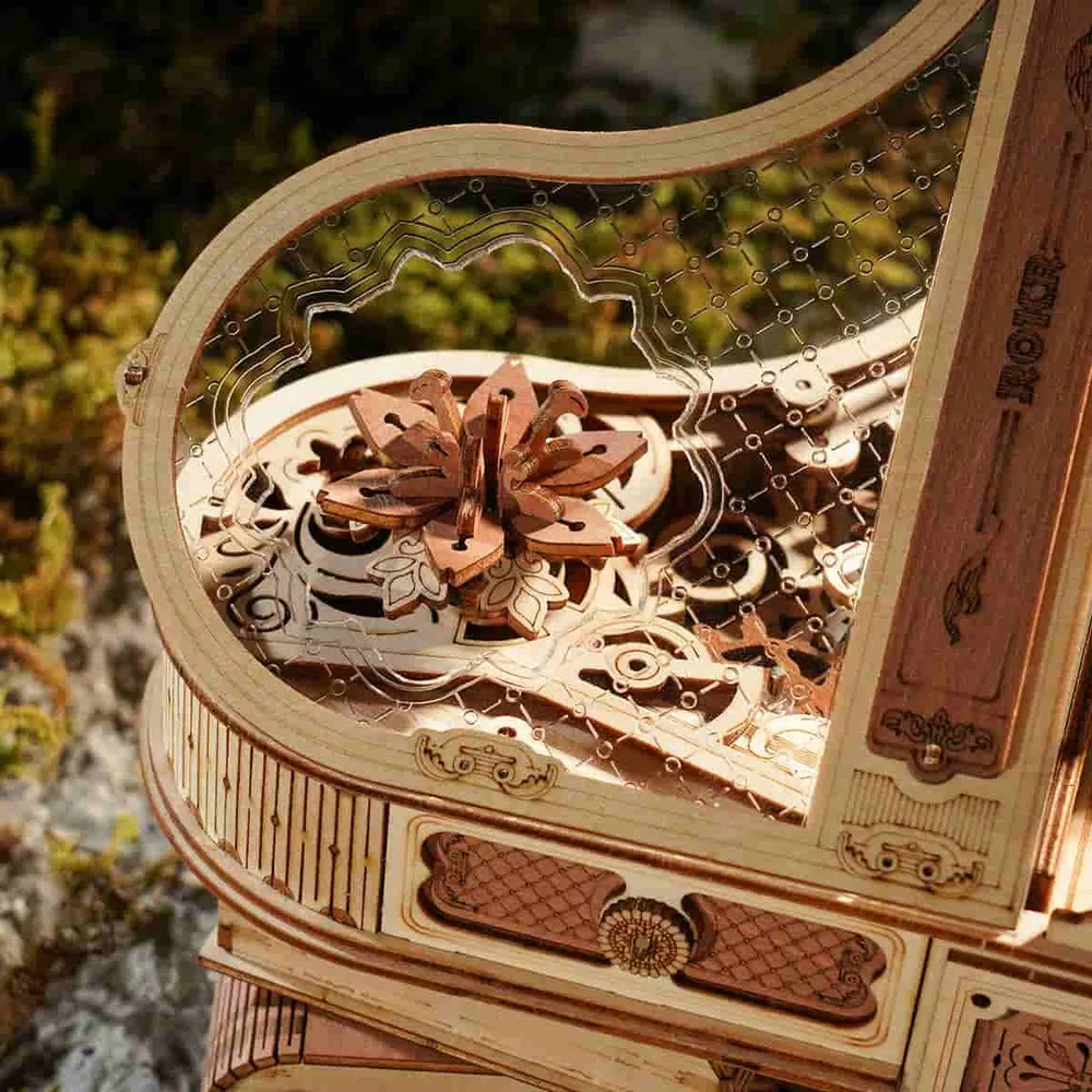 Papillon de bois rotatif visible sous le couvercle transparent gravé du piano