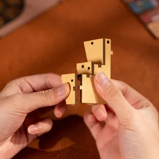 Deux mains assemblent des pièces de bois à tenons