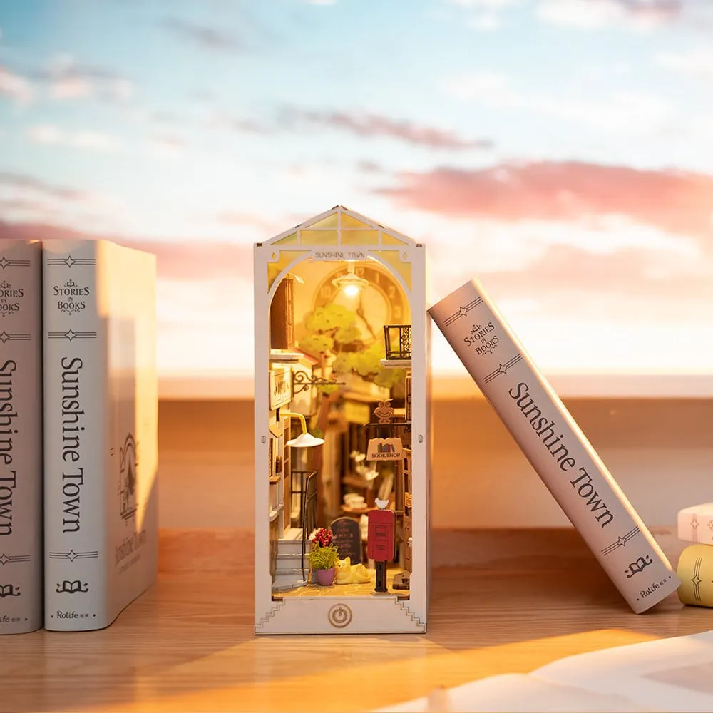 Le book nook allumé sur un rebord, face à un ciel rose