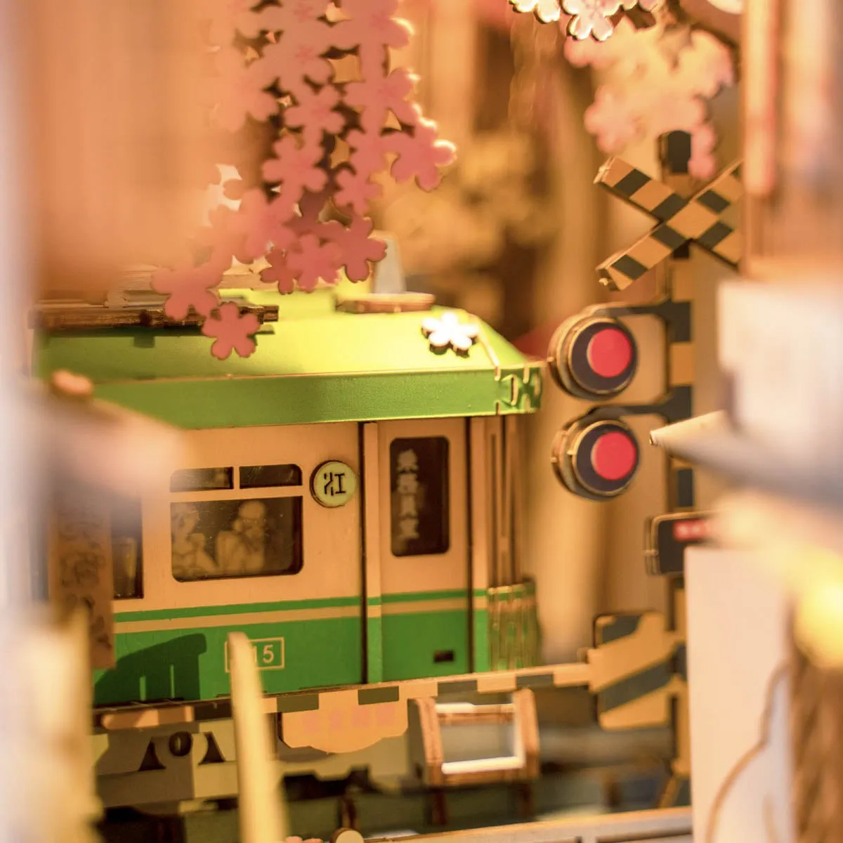 Gros plan sur le tramway vert et les feux de signalisation sous les fleurs de cerisier