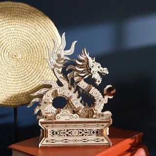 Le dragon de bois posé sur des livres à couverture rouge, devant un disque de paille tressée