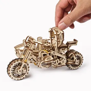 Une main manipule la moto en bois sans son side-car