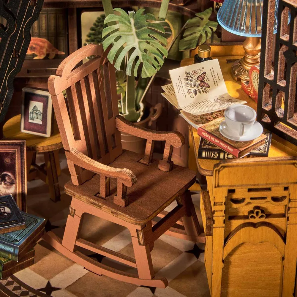 Gros plan sur le rocking-chair, le bureau et la tasse de thé miniatures