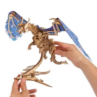 Deux mains tiennent le dragon en bois et son socle