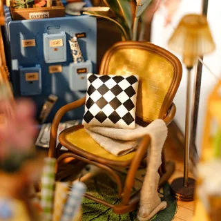 Gros plan sur le fauteuil en rotin, le coussin à damier et le casier bleu