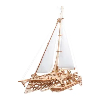 Le trimaran en bois de profil, mât, grand-voile et trinquette déployés