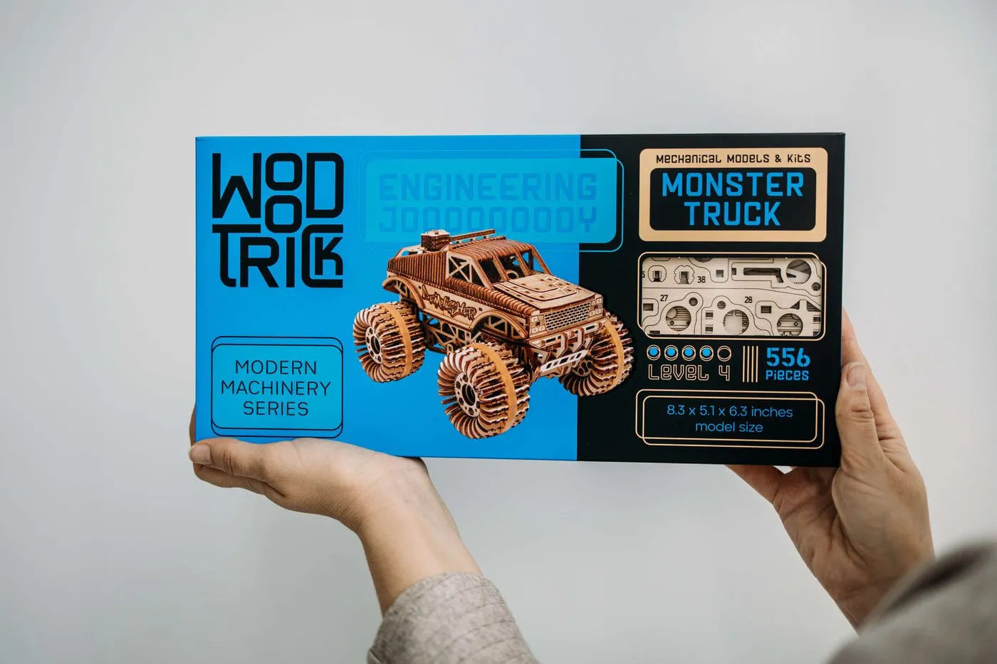 La boîte bleue du kit Monster Truck, niveau 4 et 556 pièces, tenue à deux mains