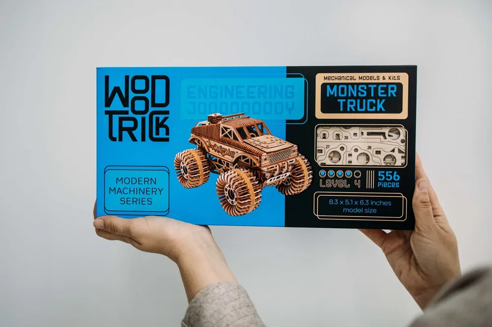 La boîte bleue du kit Monster Truck, niveau 4 et 556 pièces, tenue à deux mains
