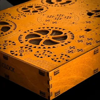 Le coffret en bois gravé du kit, décoré de motifs d’engrenages