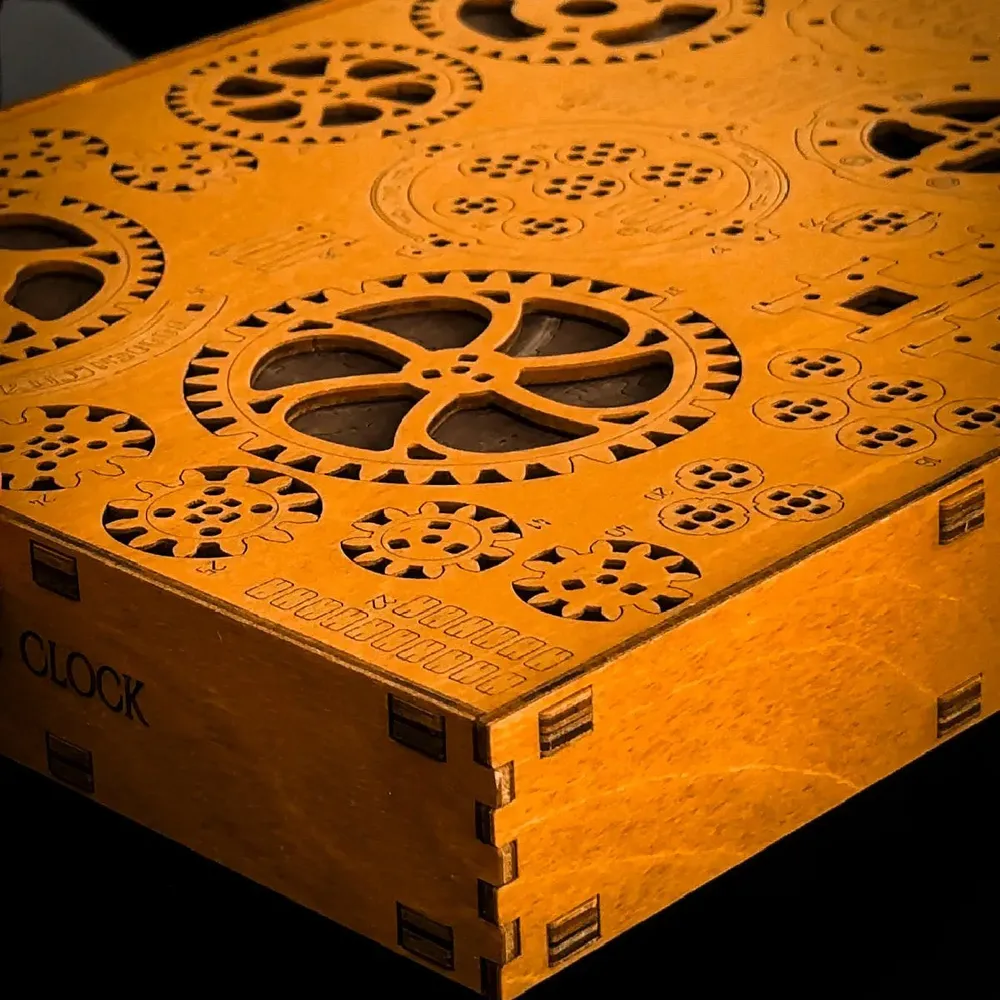 Le coffret en bois gravé du kit, décoré de motifs d’engrenages