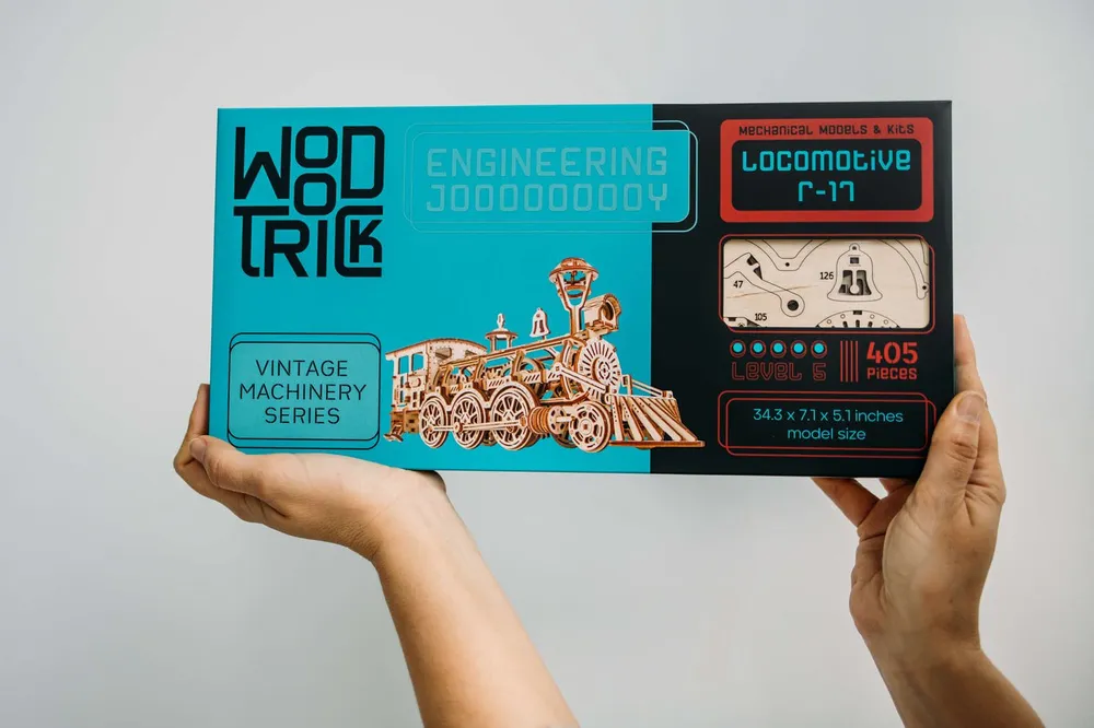 La boîte turquoise du kit Locomotive R17 tenue à deux mains